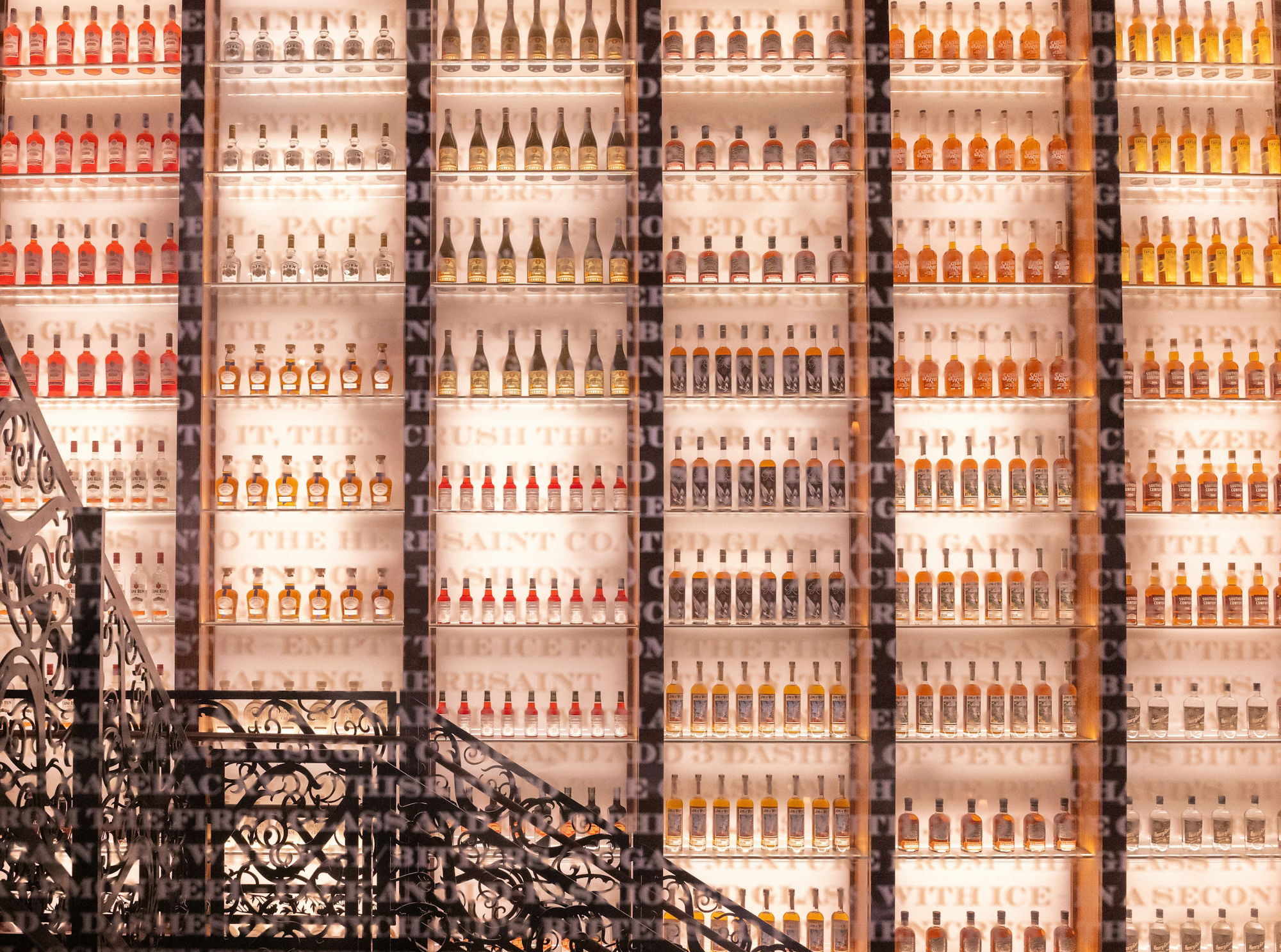 bottles-of-alcohol-line-a-brightly-lit-wall-.jpg Bottles of alcohol line a brightly lit wall.